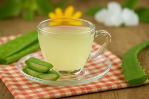 Aloe vera tea in a clear glass cup with aloe slices
