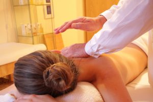 Abhyanga before yoga oil massage therapy: a practitioner applying warm oil to the back