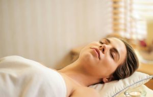 Woman relaxed during an Ayurvedic massage, symbolizing the Ayurveda and yoga partnership