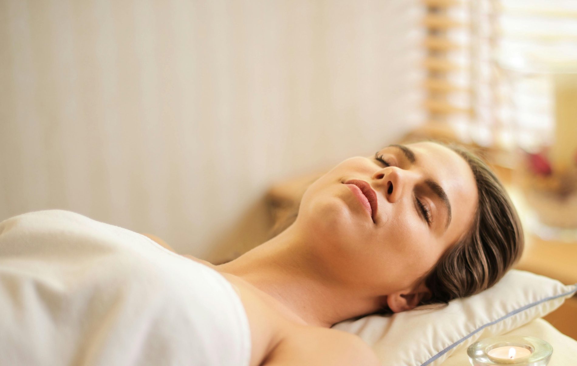 Woman relaxed during an Ayurvedic massage, symbolizing the Ayurveda and yoga partnership