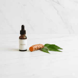 A sleek glass dropper bottle beside fresh turmeric and green neem leaves on a marble surface, representing modern Ayurvedic biohacking.