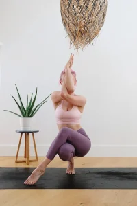 A woman practicing Garudasana (Eagle Pose) for mental focus, holistic calm, and physical balance.
